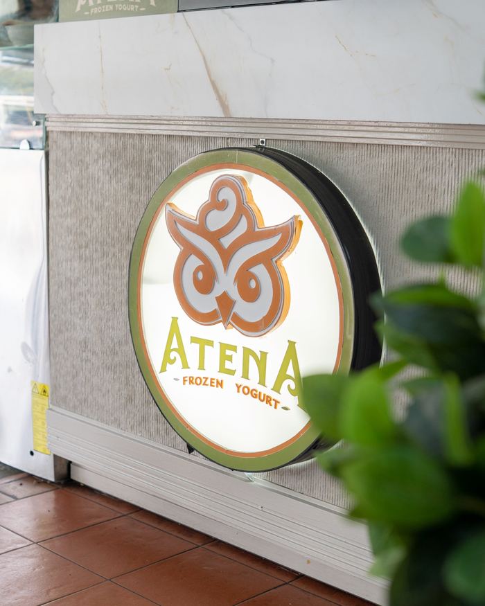 Letrero iluminado de Atena junto al mostrador, en San Antonio de los Altos